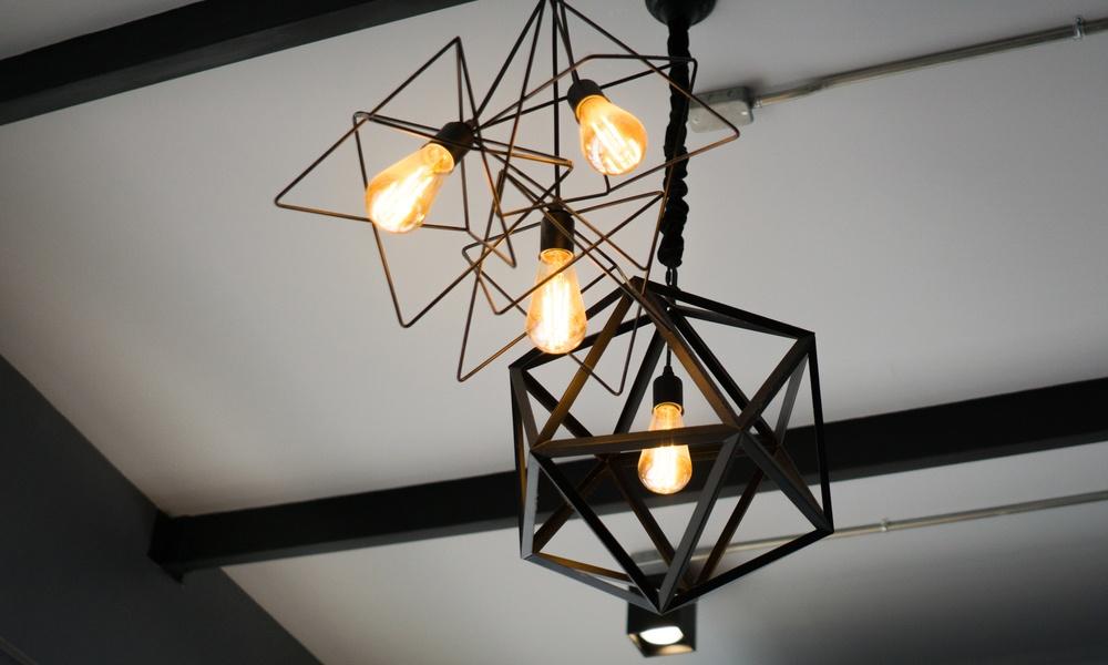 Close-up of geometric industrial-style ceiling light fixtures with exposed bulbs