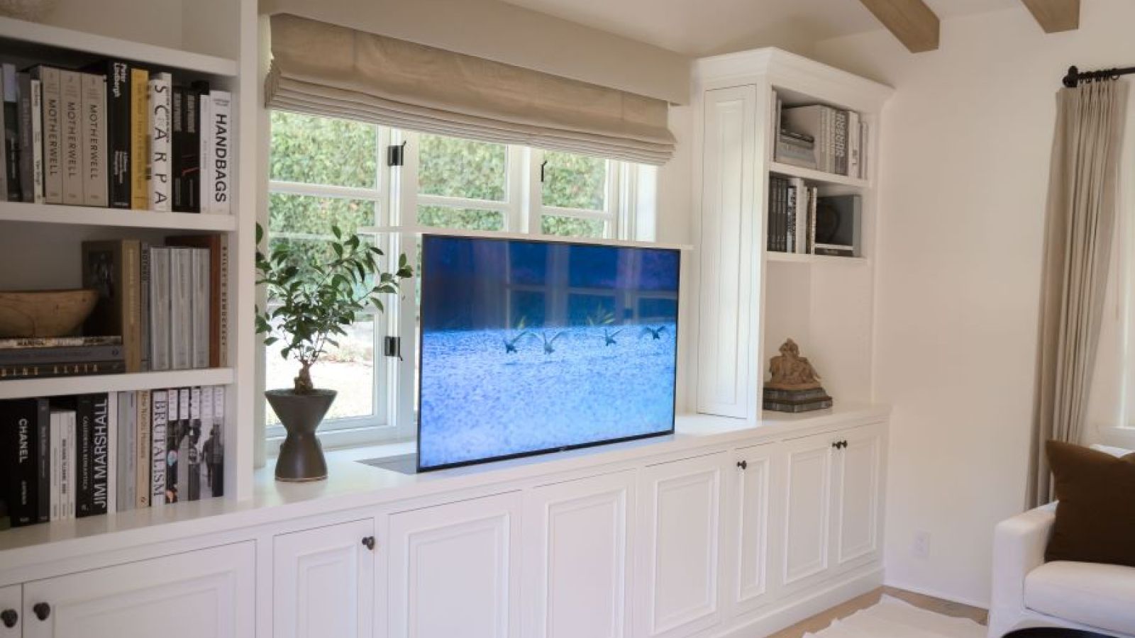Nexus TV lift built into sitting area cabinetry for a sleek and aesthetically pleasing look. 