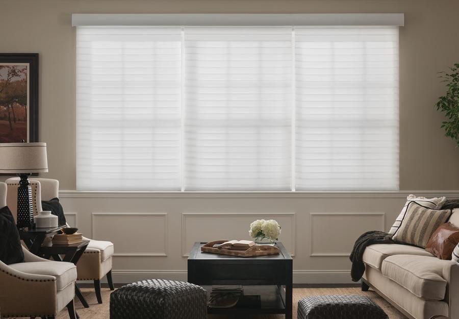 Lutron sheer blinds covering a large window in a stylish living room, allowing natural light to diffuse softly.