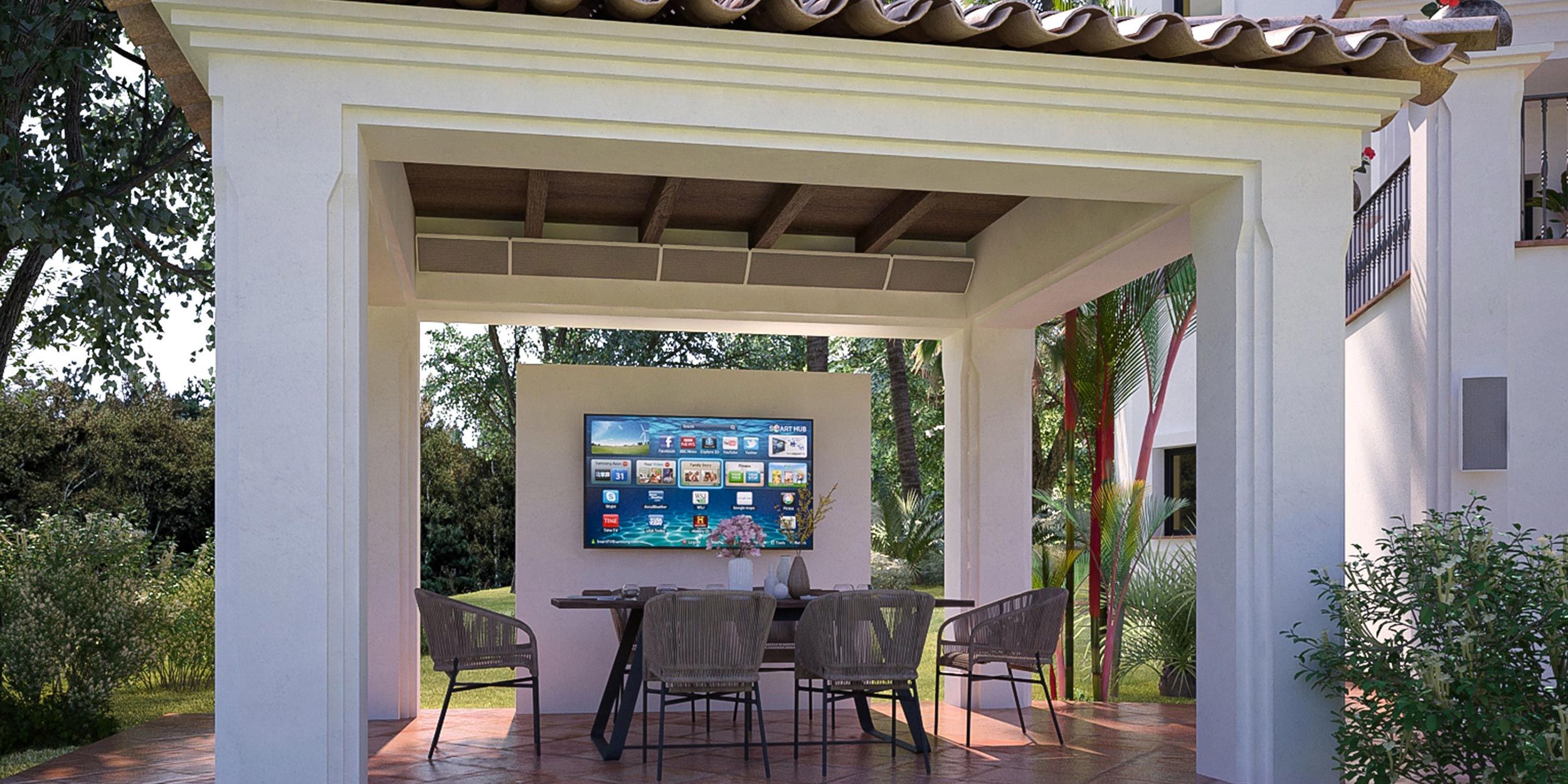 An outdoor entertainment area under a covered patio with a large screen, surrounded by nature and minimalistic design elements.